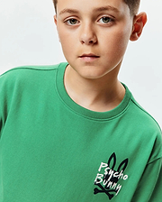 Kids Duncan Relaxed Fit Tee in vibrant green jersey, featuring a prominent distressed white and black Psycho Bunny skull logo with bunny ears and crossbones on the left chest.