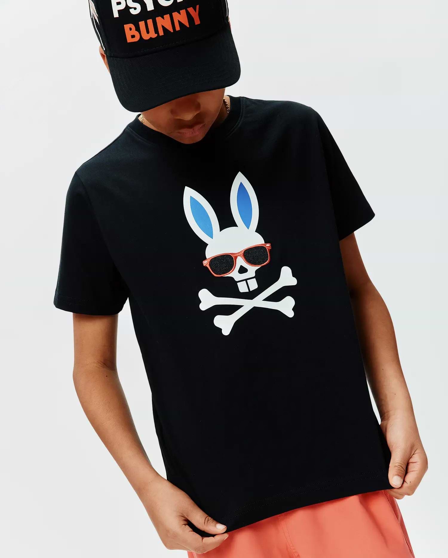 Kids Sunny Graphic Tee, black classic fit jersey t-shirt featuring a large central white bunny skull with blue ears, red sunglasses, and white crossbones graphic.