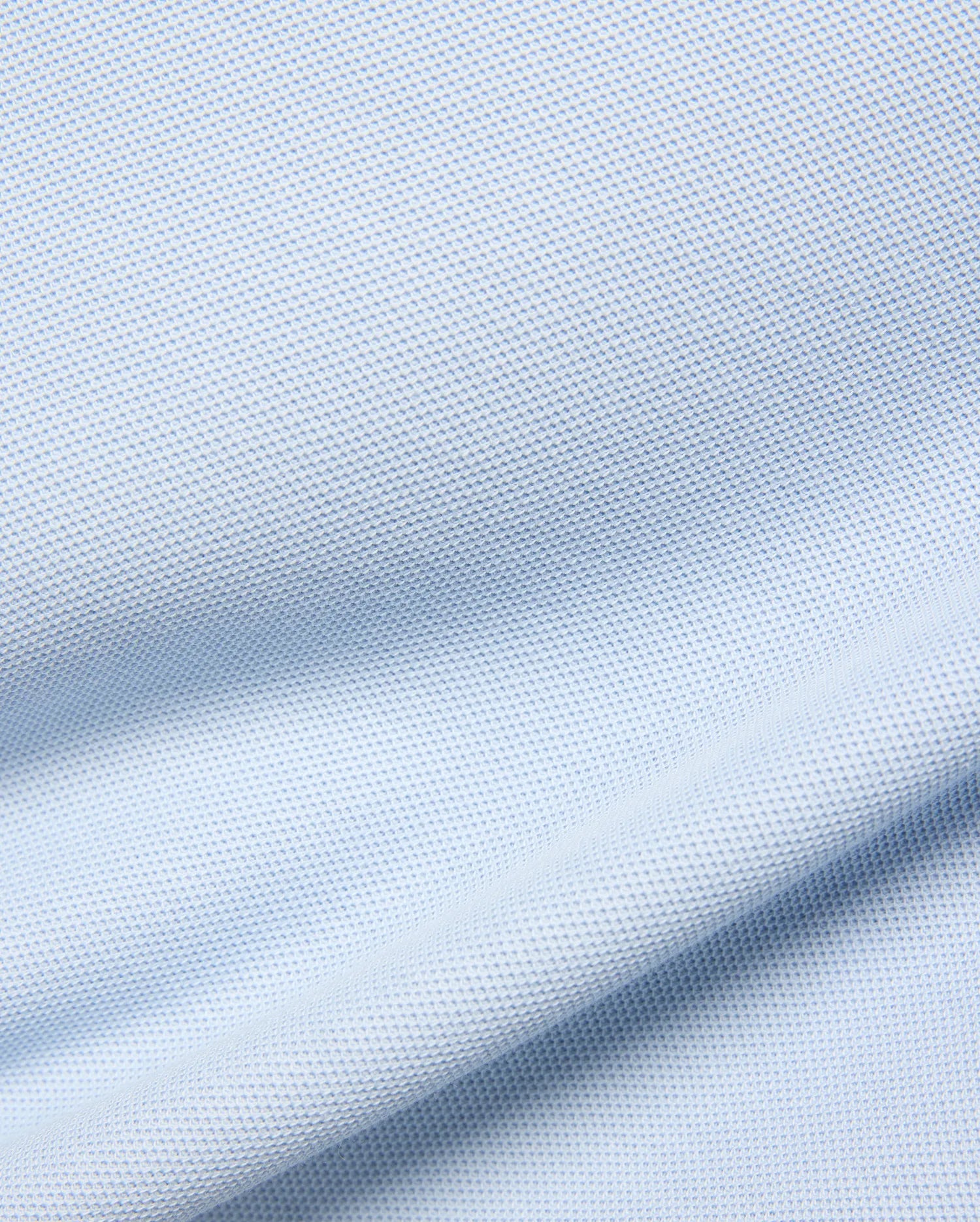 Kids Taylor Pique Tee in a soft, pale blue, featuring a finely textured, breathable pique knit fabric with gentle, flowing drapes and subtle shadows highlighting its classic weave. (5)