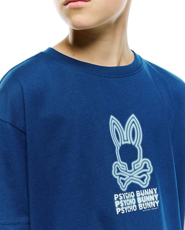 Kids Alex Relaxed Back Graphic Tee, a deep royal blue jersey shirt with a large, textured white and light blue outlined Psycho Bunny skull and stacked text graphic.