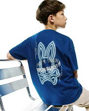 Kids Alex Relaxed Back Graphic Tee in royal blue jersey knit, featuring a large, light blue and white halftone Psycho Bunny skull logo graphic on the back, flanked by vertical Psycho Bunny text.