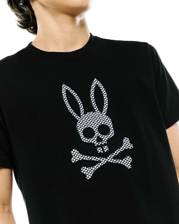Psycho Bunny Kids Stan Graphic Tee in black, a classic fit jersey t-shirt with a prominent, embroidered black and white checkered bunny skull and crossbones logo on the chest.