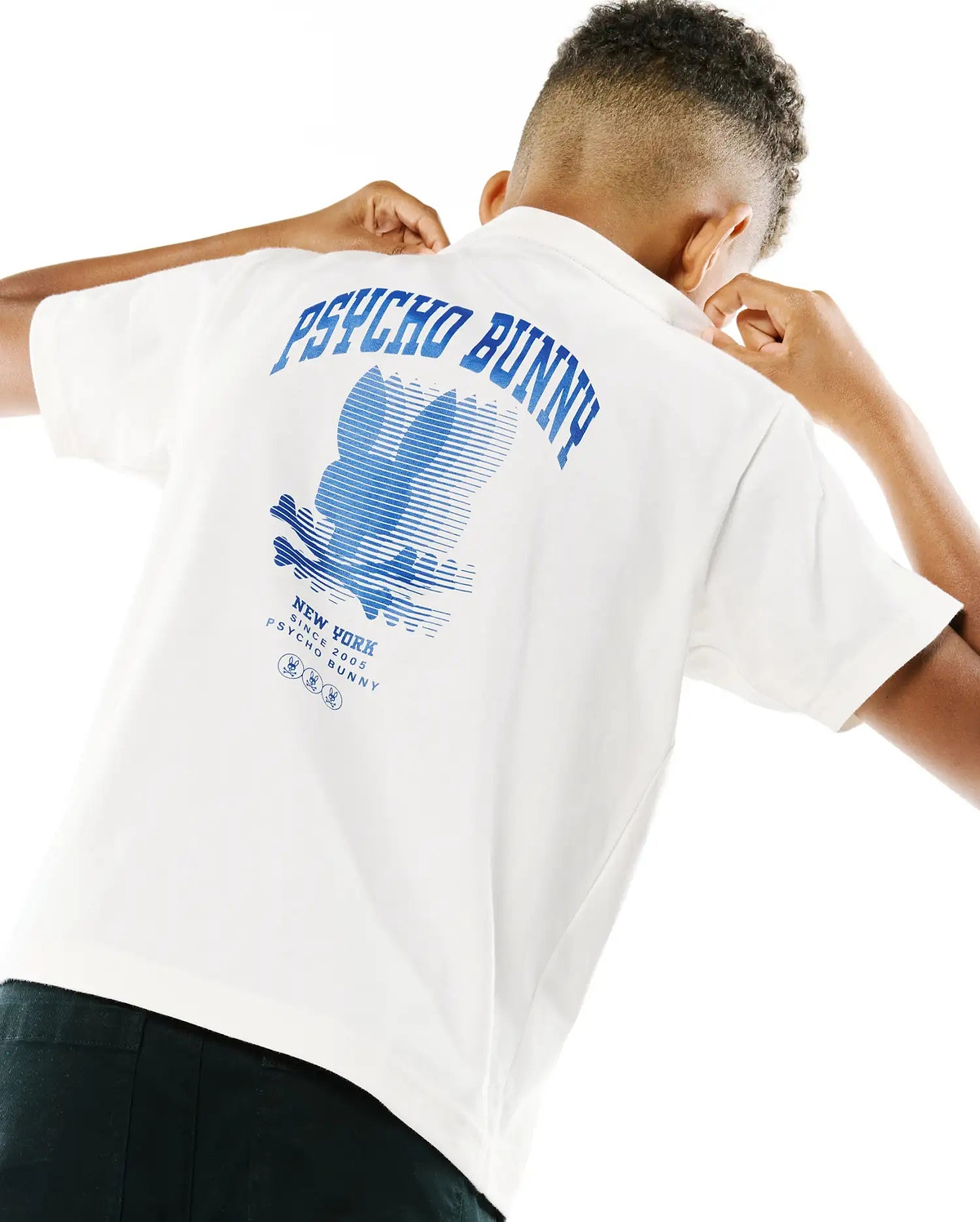 White Kids Nathaniel Back Graphic Tee in soft jersey, featuring a large blue Psycho Bunny text and stylized bunny skull logo print on the back, with New York Since 2005 text and small bunny logos.