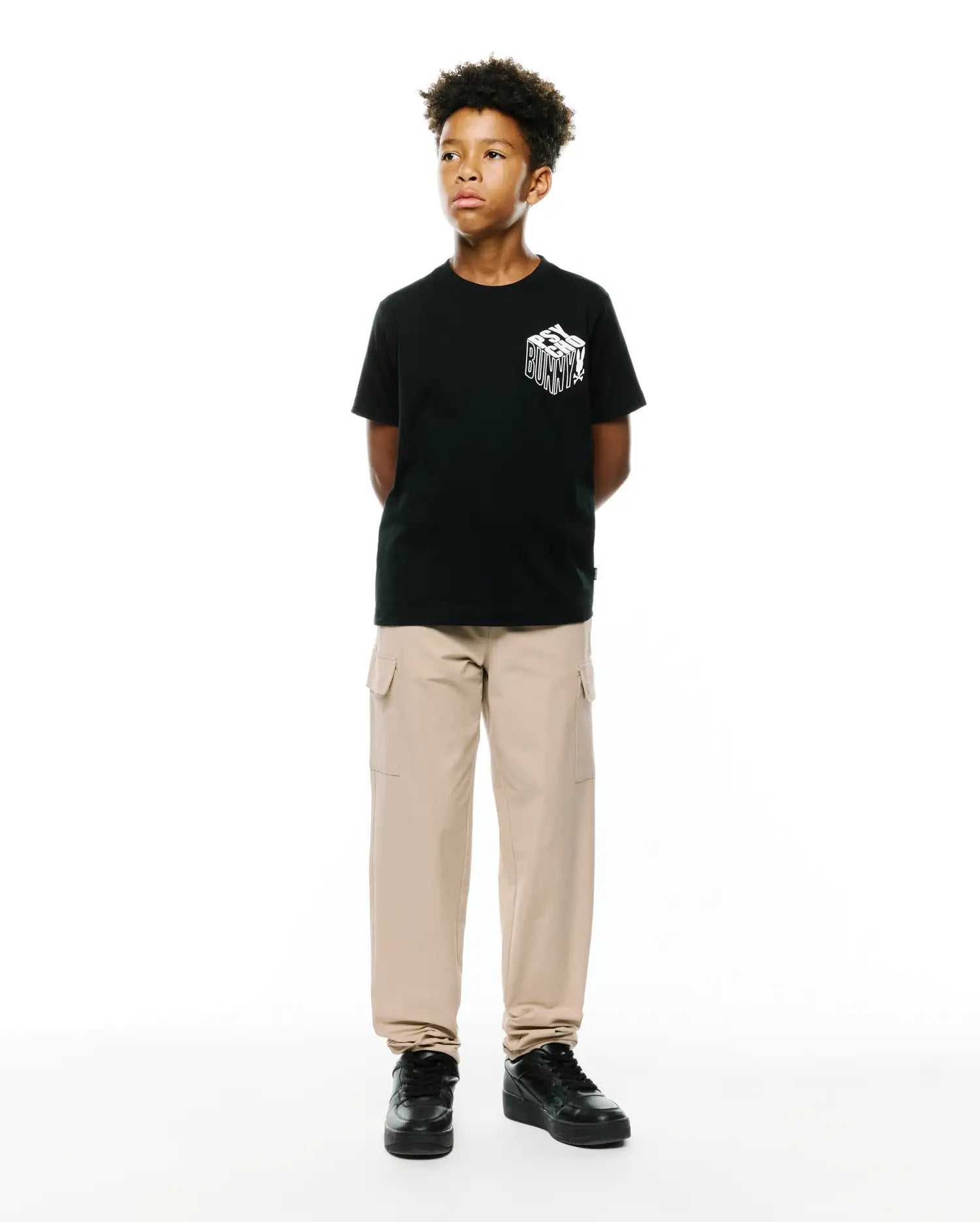Kids Conan Back Graphic Tee, a black classic fit jersey t-shirt with a bold white 3D-effect Psycho Bunny text graphic prominently displayed on the front chest.