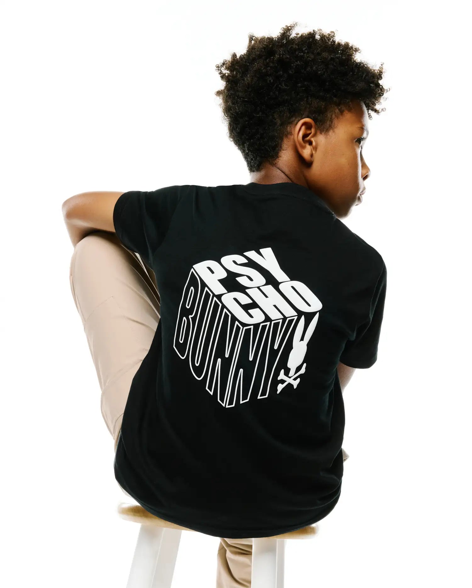 Kids Conan Back Graphic Tee, a black classic-fit jersey t-shirt featuring a large white 3D block PSYCHO BUNNY text graphic with the iconic skull logo on the back.