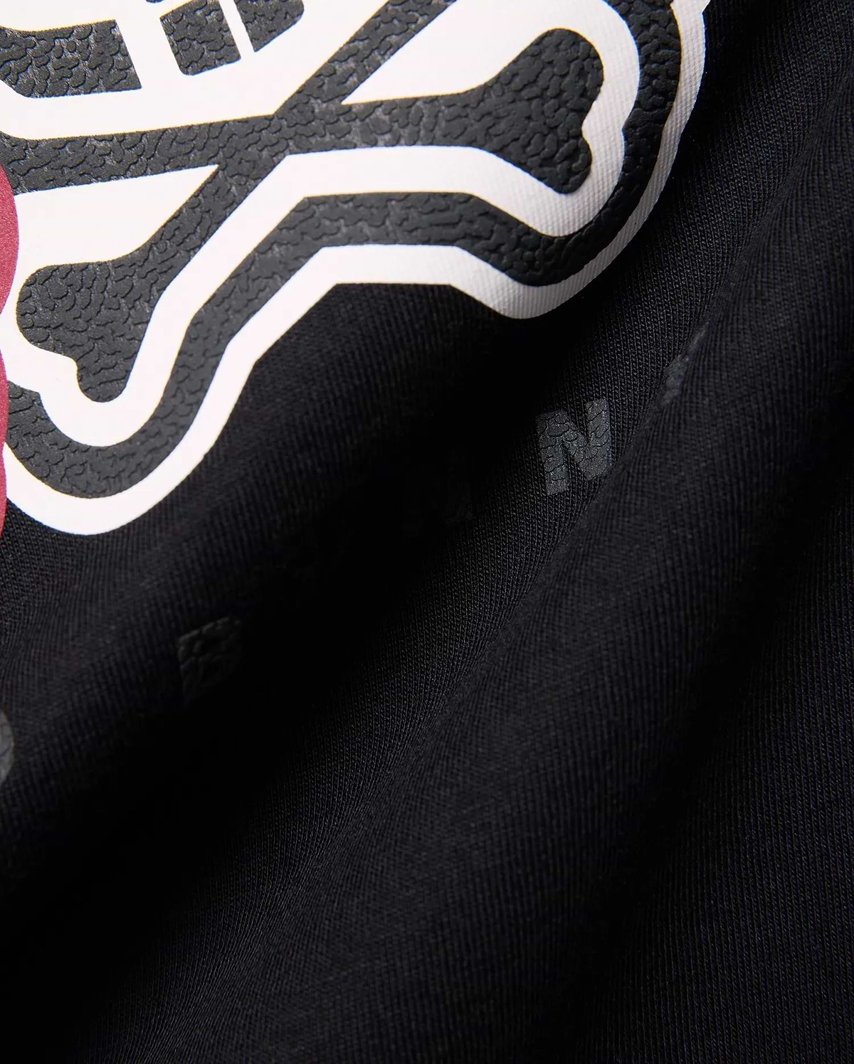 Kids Ledger Graphic Tee in black jersey knit, featuring a large, raised white and textured black Psycho Bunny skull graphic with a hint of dark pink, and subtle background letter prints.