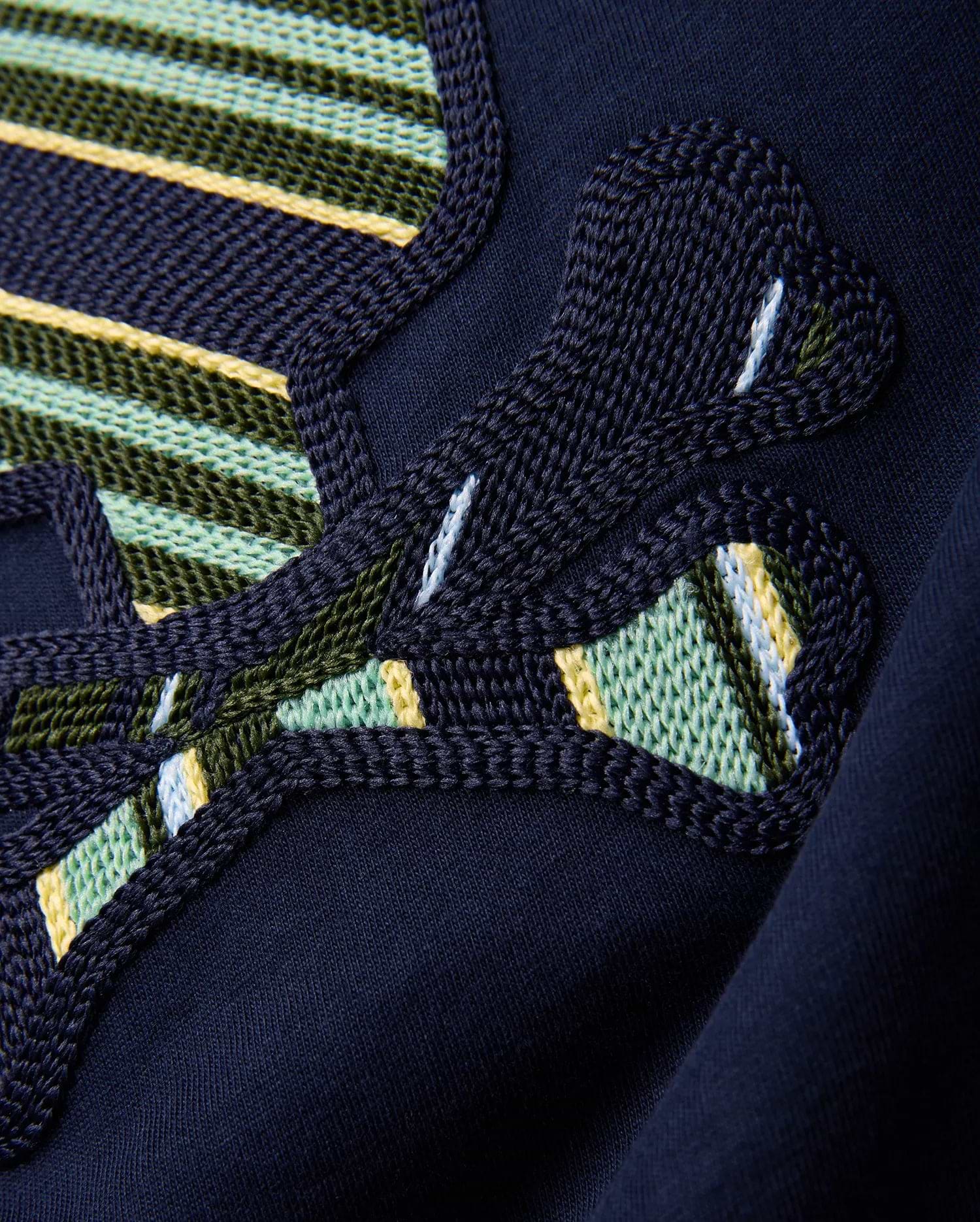 Kids Drew Embroidered Graphic Tee in classic navy jersey, showcasing a large, intricately textured graphic with bold green, yellow, light blue, and white striped embroidery.