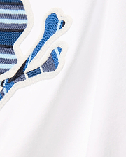 Kids Drew Embroidered Graphic Tee in white jersey, featuring a large, prominent chest Psycho Bunny skull logo with blue, light blue, and dark blue striped embroidery, outlined in white.