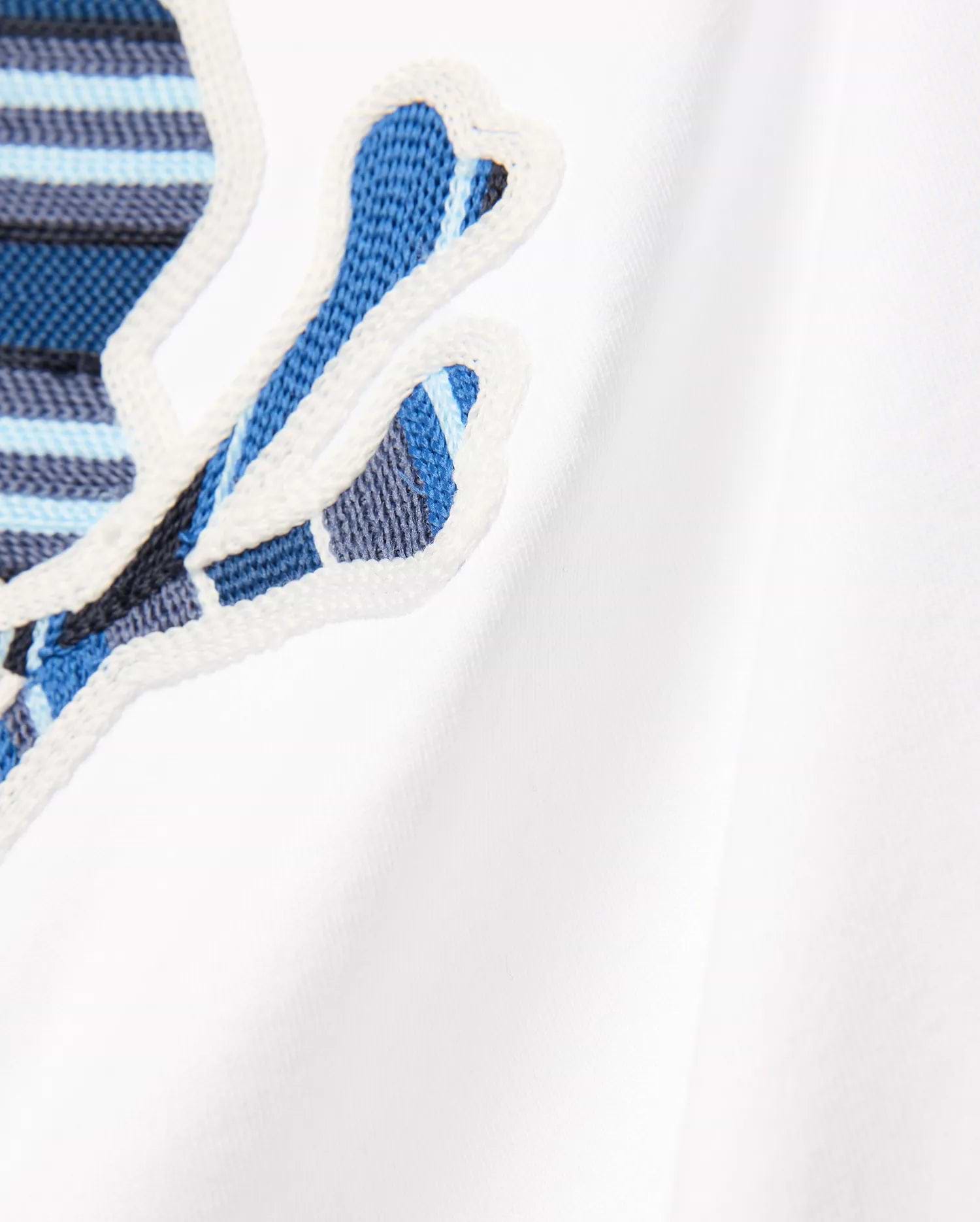 Kids Drew Embroidered Graphic Tee in white jersey, featuring a large, prominent chest Psycho Bunny skull logo with blue, light blue, and dark blue striped embroidery, outlined in white.