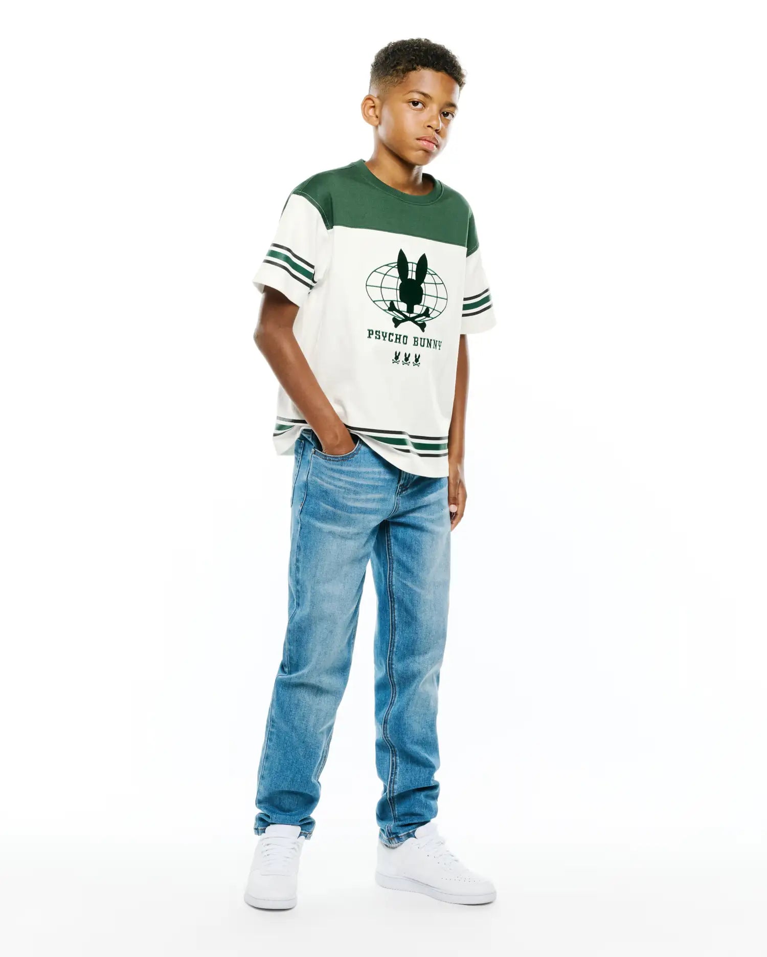 Kids Mike Graphic Jersey Tee, a classic fit off-white jersey t-shirt featuring dark green color-block shoulders, striped sleeves, and a large central Psycho Bunny globe graphic with text and three smaller bunny logos.
