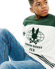 Kids Mike Graphic Jersey Tee, white and dark green color block with a large central Psycho Bunny globe graphic, text, and three small bunny skull logos, plus green and black sleeve stripes.