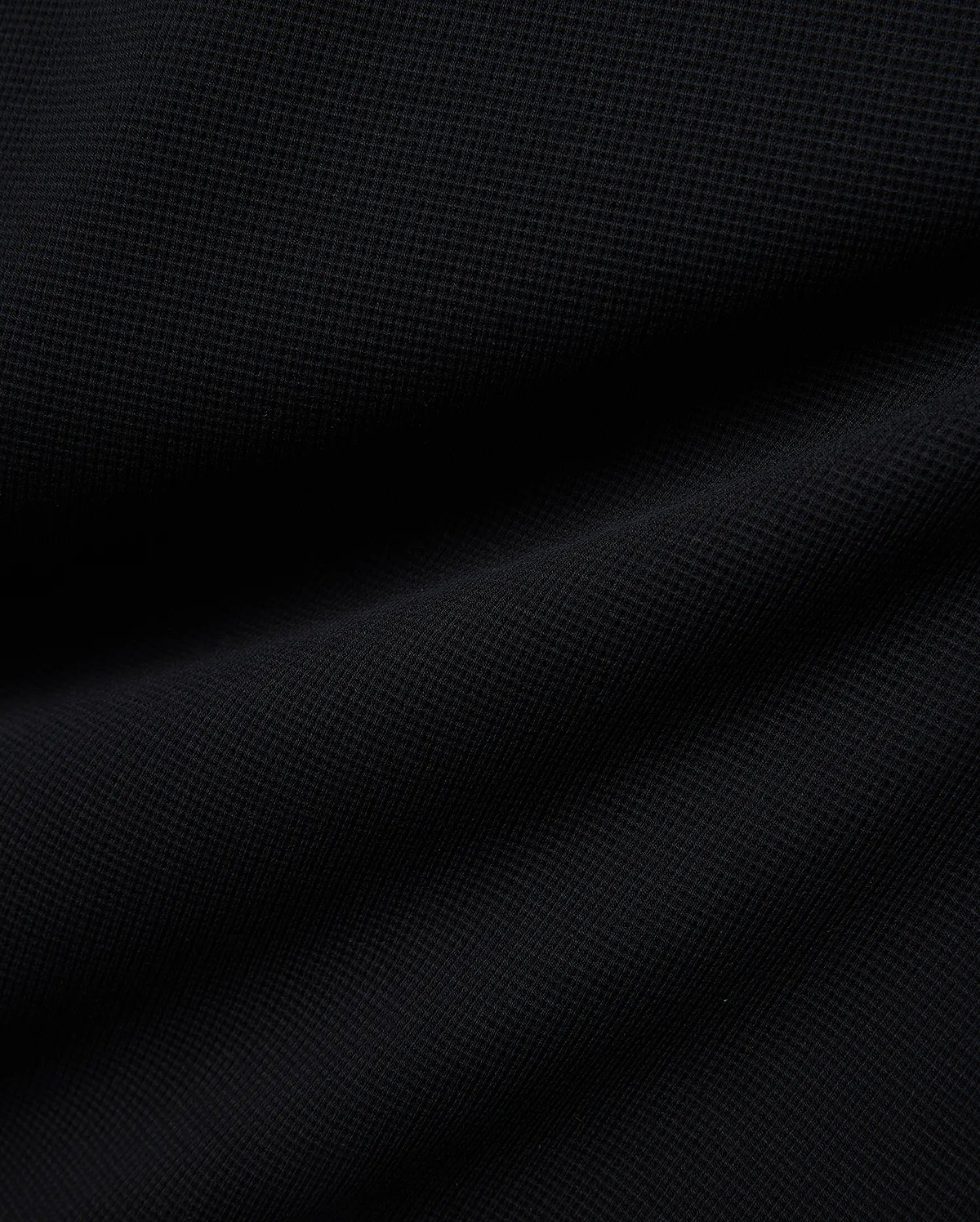 Premium Kids Maxton Waffle Tee in a deep black, featuring a distinct, soft waffle knit fabric texture with subtle raised squares and gentle folds, ensuring comfortable, refined style.
