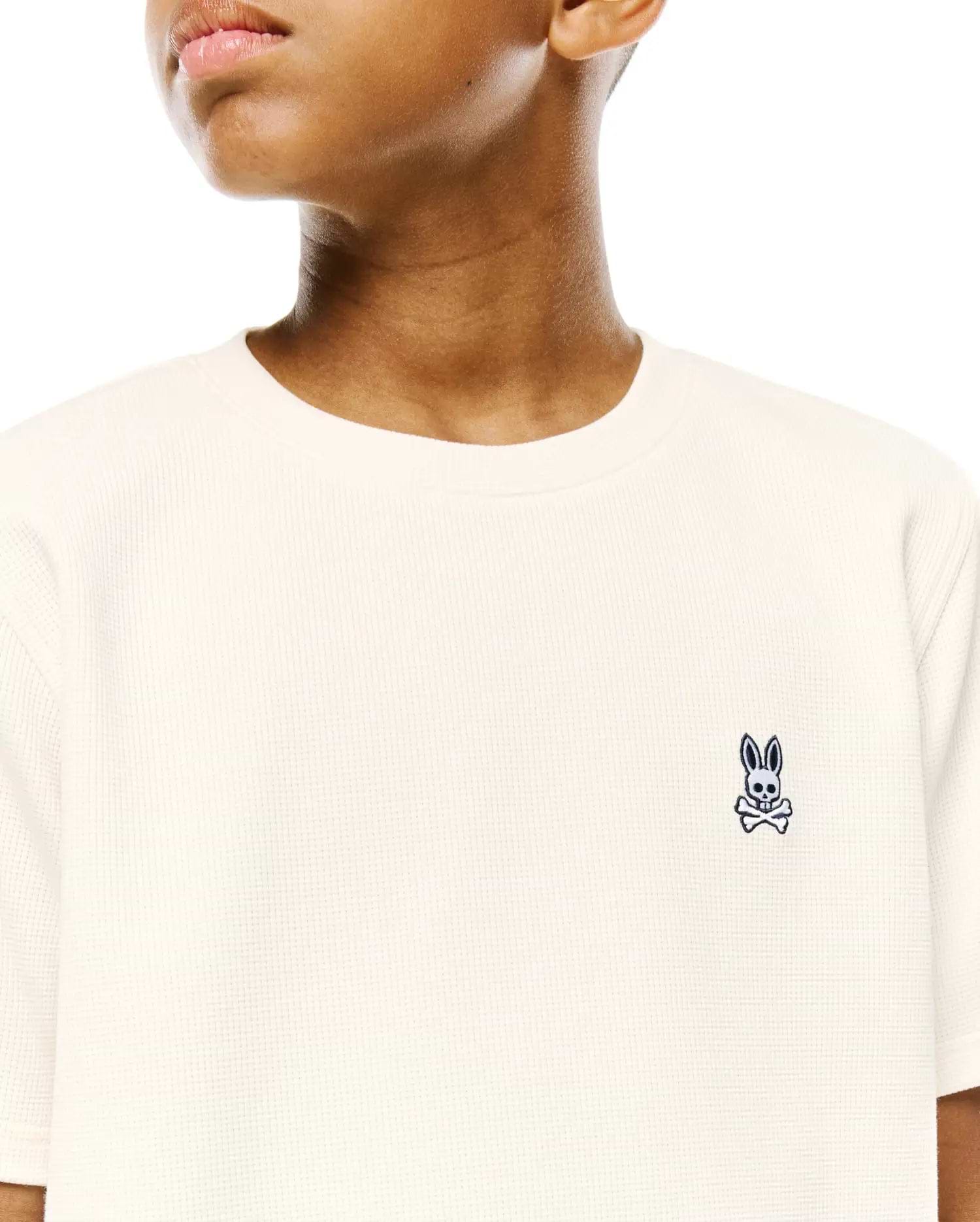 Kids Maxton Waffle Tee in cream, featuring a classic fit and waffle knit texture, with a small embroidered navy Psycho Bunny skull logo on the left chest.