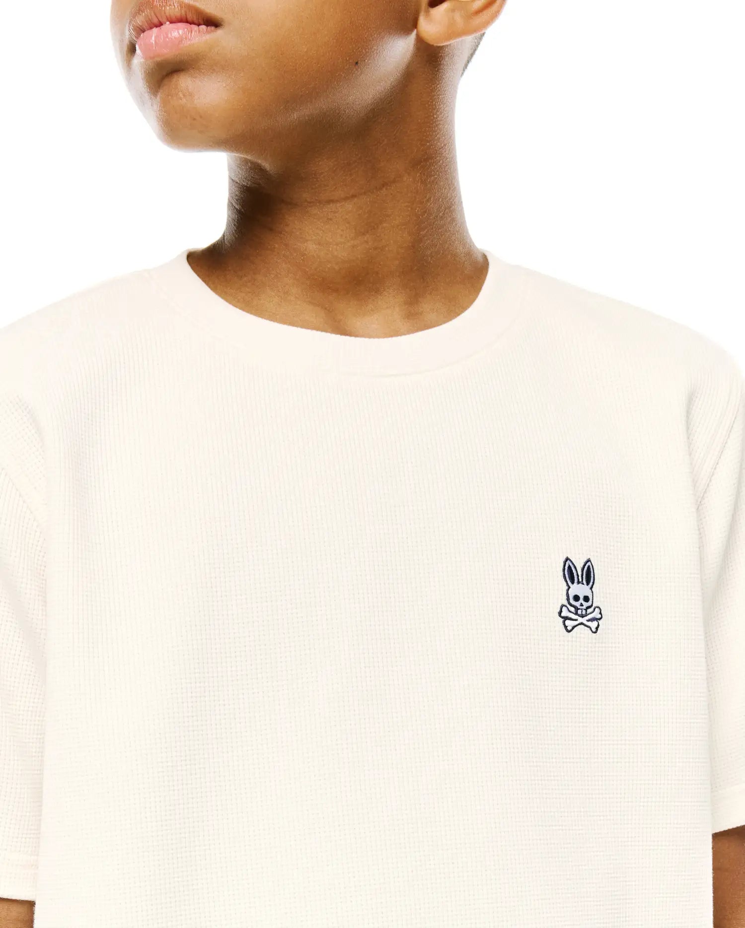 Kids Maxton Waffle Tee in cream, featuring a classic fit and waffle knit texture, with a small embroidered navy Psycho Bunny skull logo on the left chest.