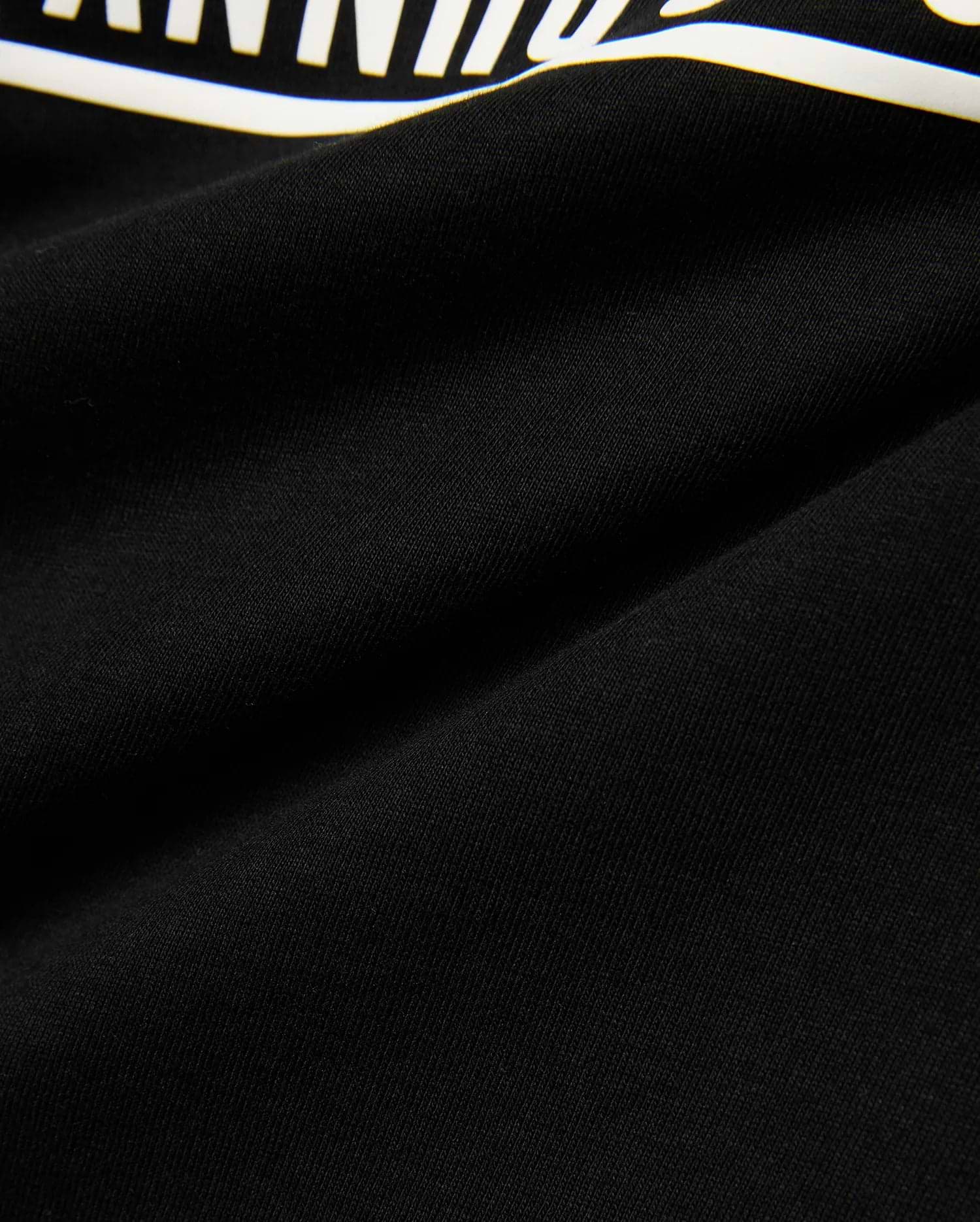 Kids' Raj Pima Graphic Tee, a premium black Pima cotton jersey knit with a soft texture, featuring a prominent, bold white graphic print, embodying refined streetwear style. (6)