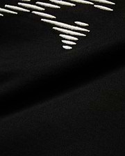 Kids' Slade Pima Graphic Tee, a black Pima cotton jersey t-shirt with a refined streetwear feel, featuring a prominent white embroidered stylized graphic design. (6)
