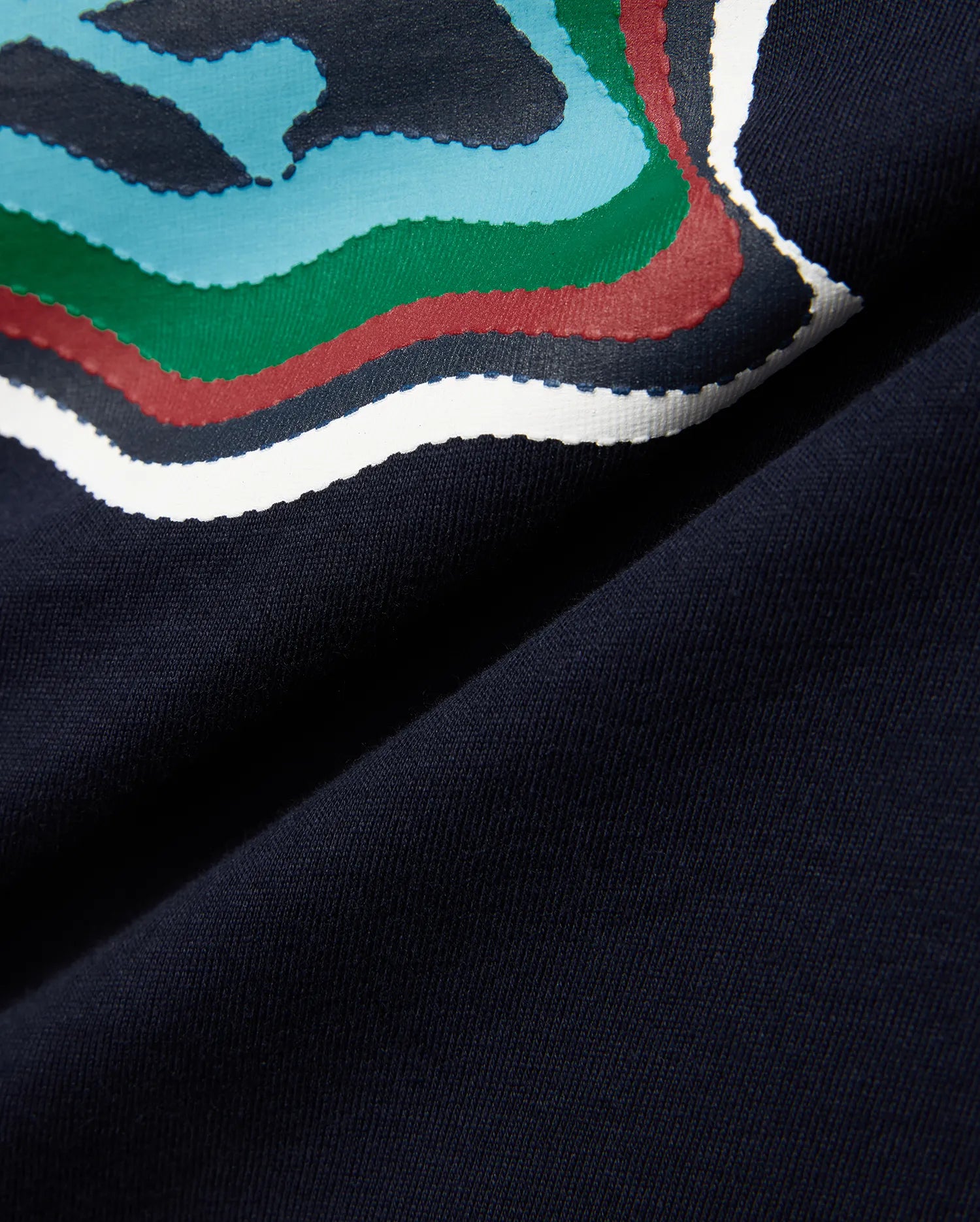 Kids' Klaus Graphic Tee in navy jersey knit, featuring a large, textured graphic print with wavy lines in blue, green, red, and white, hinting at the iconic Psycho Bunny skull. (6)