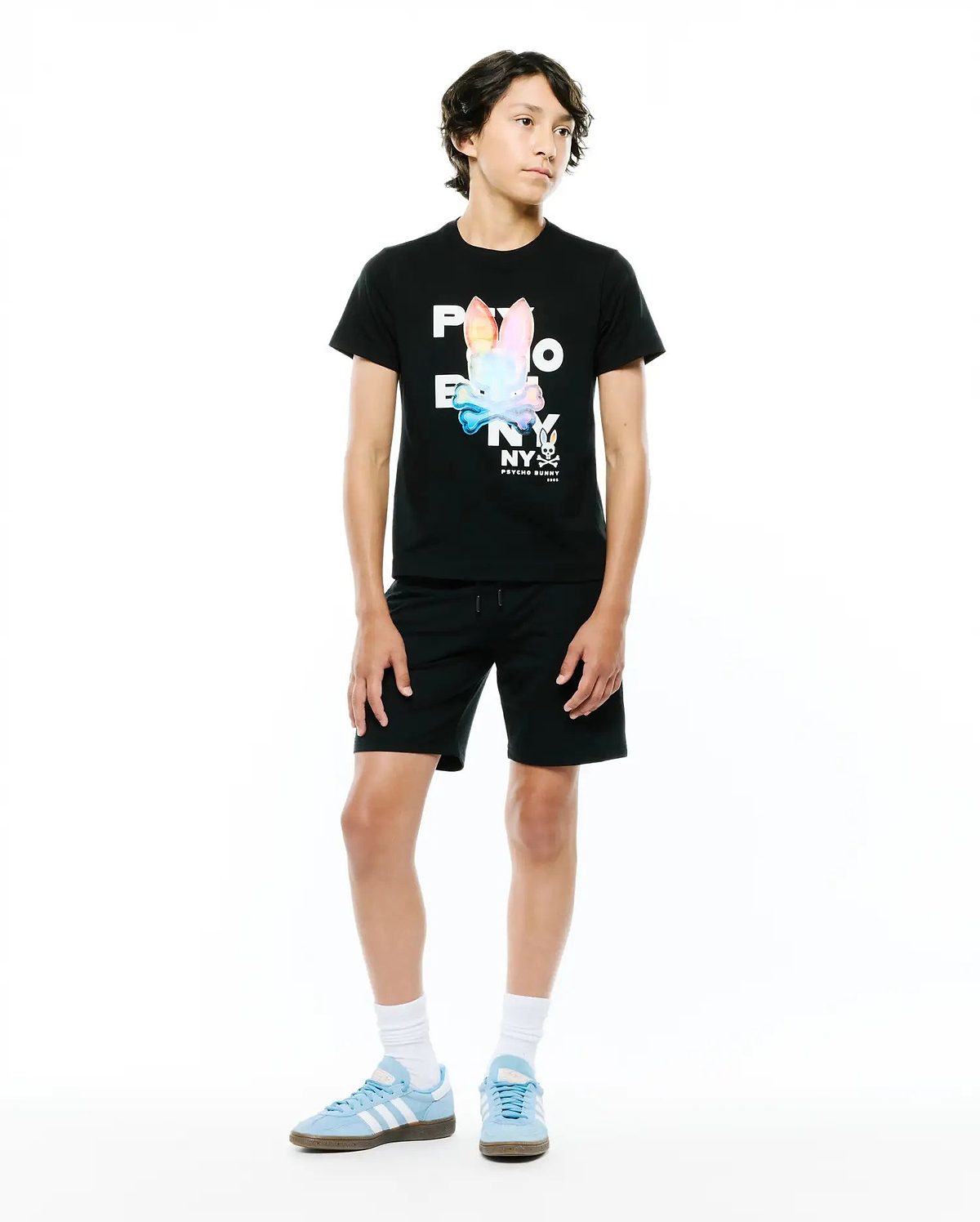 Black Kids Kenji Graphic Tee with a classic fit, made from soft jersey, featuring a large multicolor iridescent Psycho Bunny NY skull logo graphic on the chest, paired with black relaxed fit knit shorts.