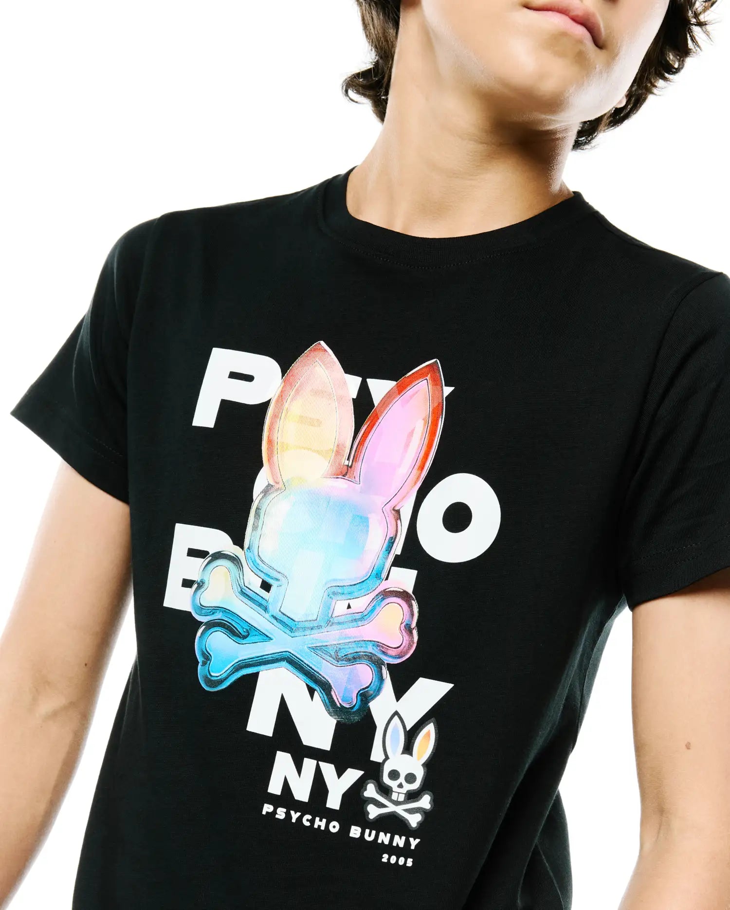 Kids Kenji Graphic Tee, black classic fit jersey t-shirt featuring a large iridescent rainbow bunny skull graphic on the chest, white PSYCHO BUNNY text, and a small rainbow-eared bunny skull logo.