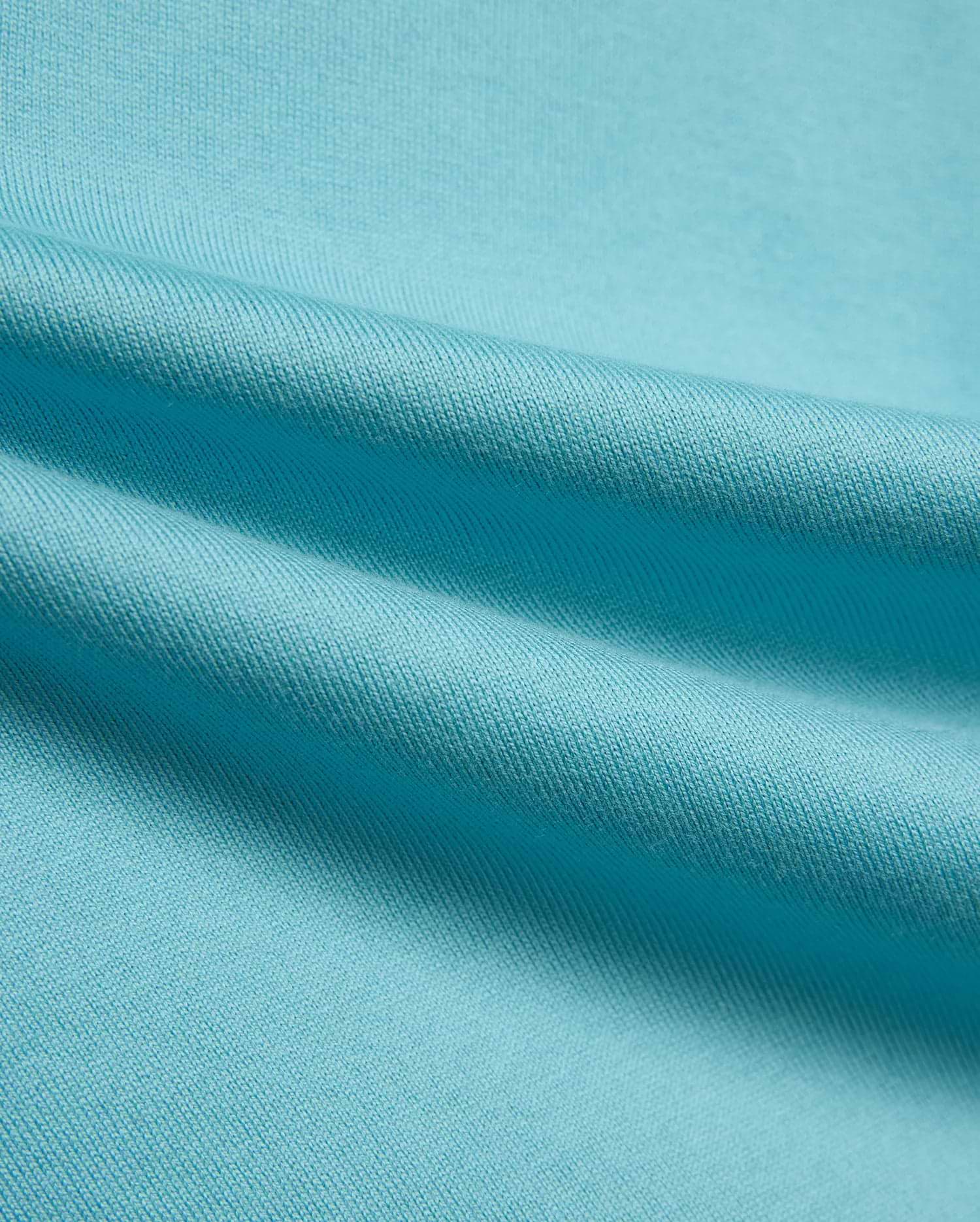 Kid's Norman Longsleeve Oversized Tee in vibrant aqua blue, showcasing its premium, finely woven cotton jersey knit fabric with soft, flowing drapes. (6)