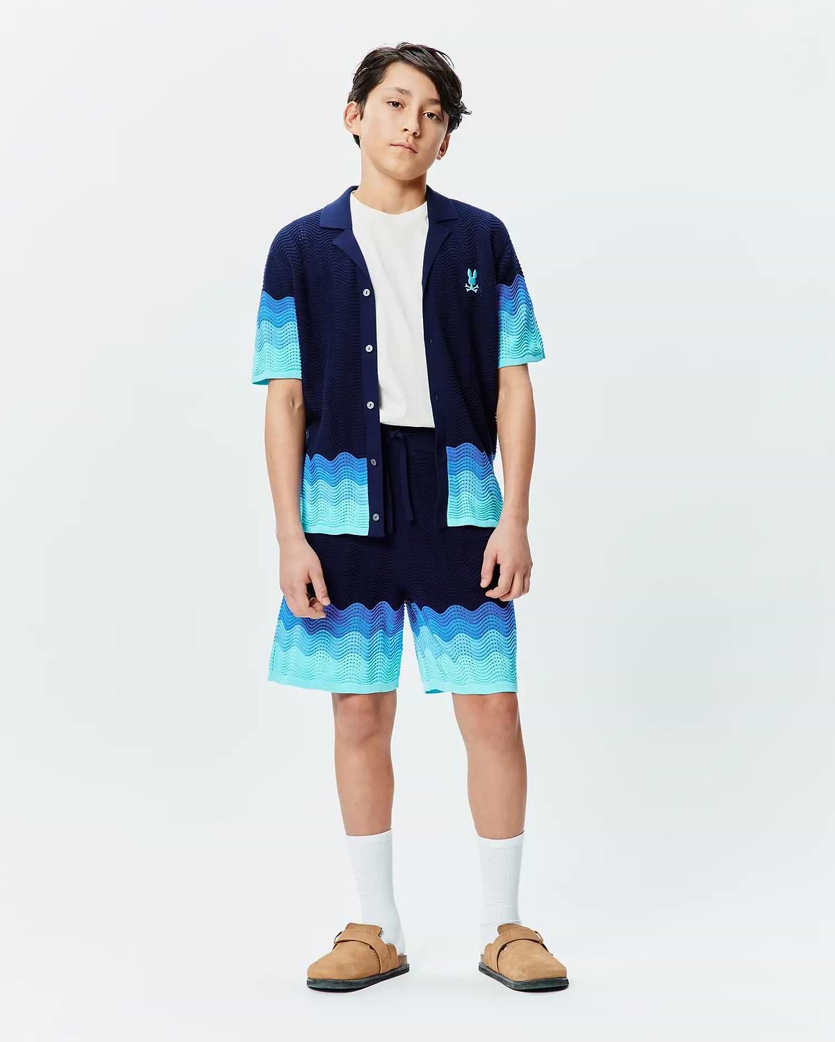 Kids Holden Oversized Knit Shirt and matching shorts set in navy blue with wavy gradient blue stripes, featuring a relaxed fit, textured knit fabric, and a small embroidered Psycho Bunny logo on the chest. (4)