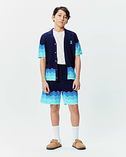 Kids Holden Oversized Knit Shirt and matching shorts set in navy blue with wavy gradient blue stripes, featuring a relaxed fit, textured knit fabric, and a small embroidered Psycho Bunny logo on the chest. (4)