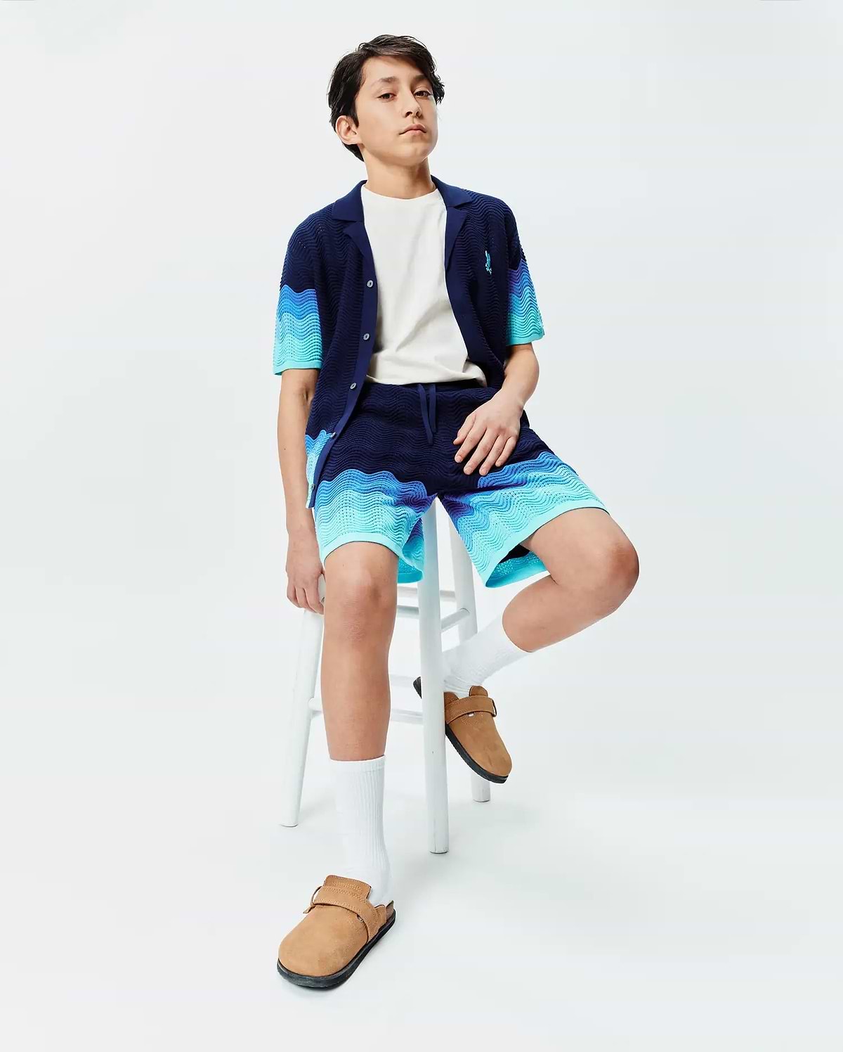 Kids Holden Oversized Knit Shirt and matching shorts in navy blue with a wavy light blue and turquoise knit pattern, featuring a small embroidered Psycho Bunny skull logo on the left chest. (3)