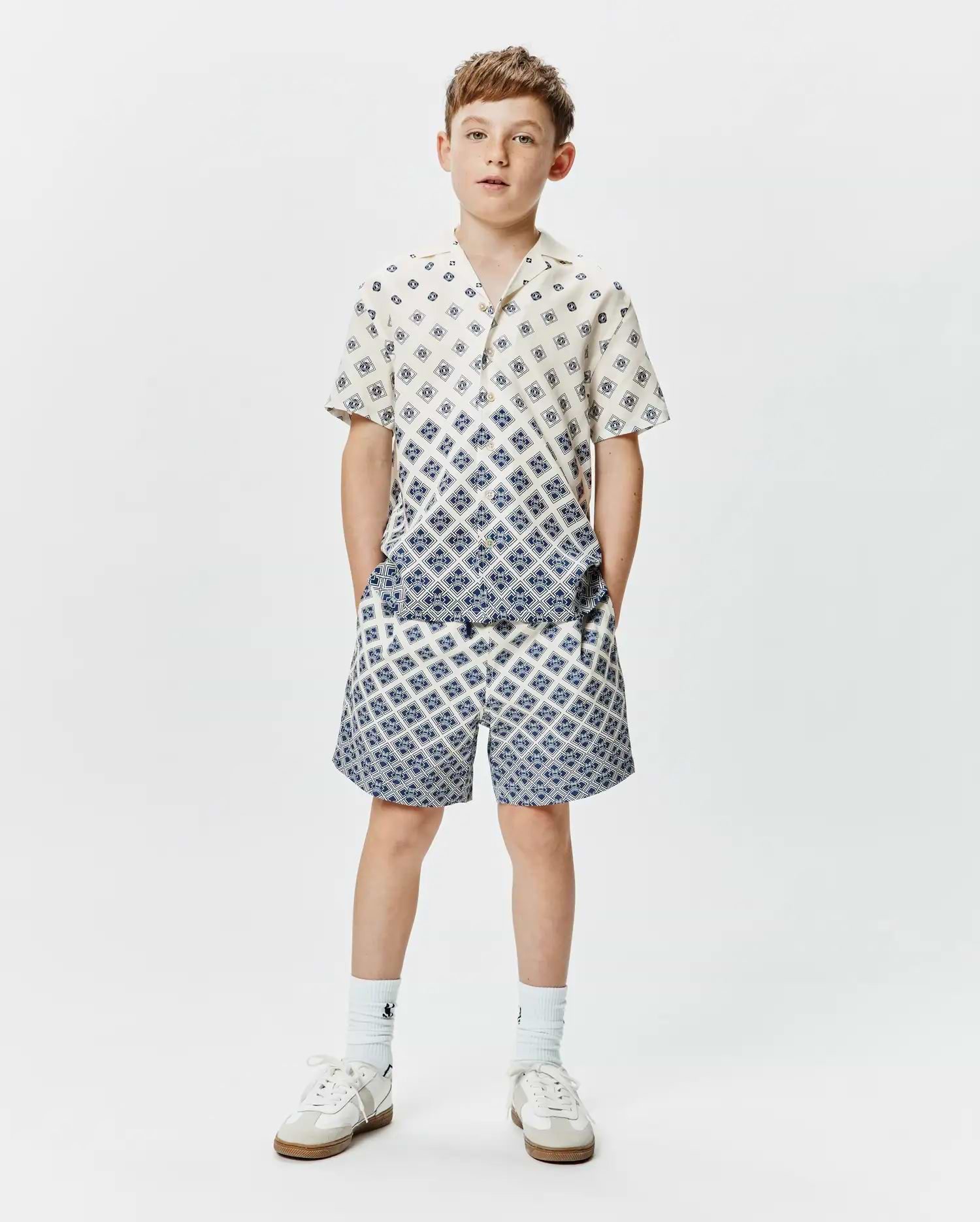 Psycho Bunny Kids Tobias Tencel Shirt and matching shorts, cream with a blue geometric diamond pattern, relaxed fit, featuring a gradient effect on the shirt.