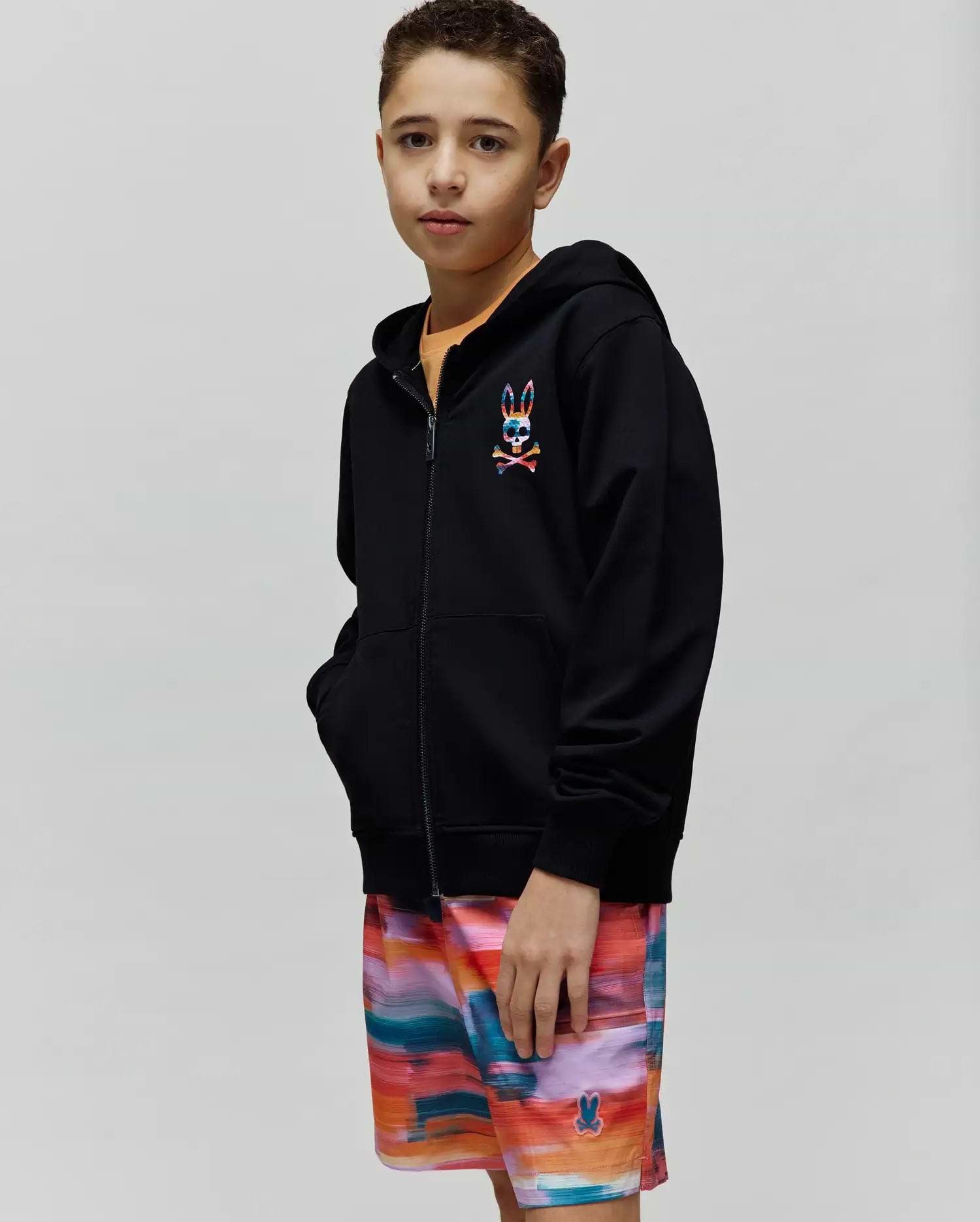 Kids Raphael French Terry Full Zip Hoodie in black, featuring a relaxed fit and a small, embroidered, multi-colored Psycho Bunny skull and crossbones logo on the left chest.