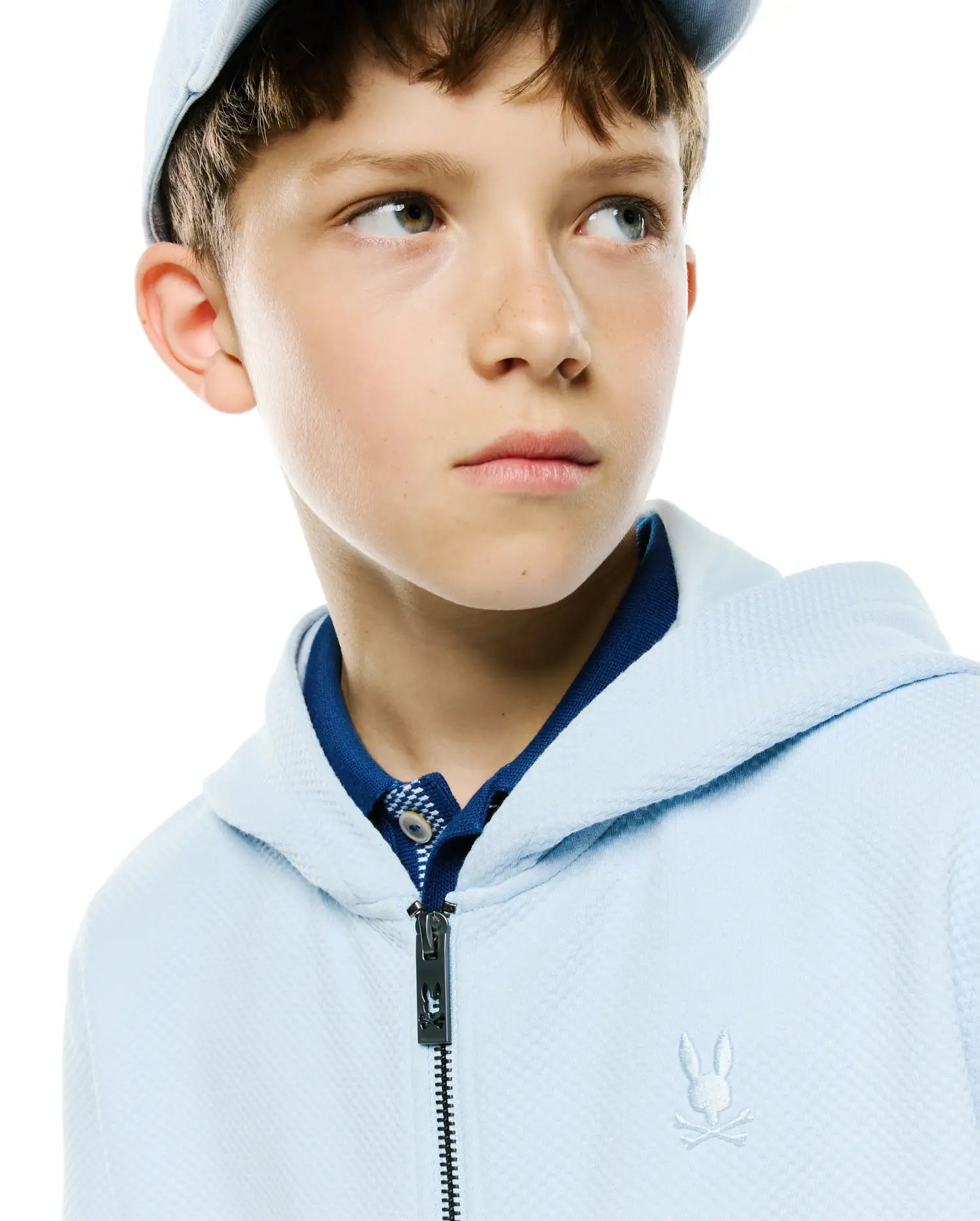 Kids Marc Textured Full Zip Hoodie in light blue, featuring a subtle textured fabric, dark blue polo collar, full zip with custom Psycho Bunny skull logo pull, and small white embroidered bunny skull on left chest.