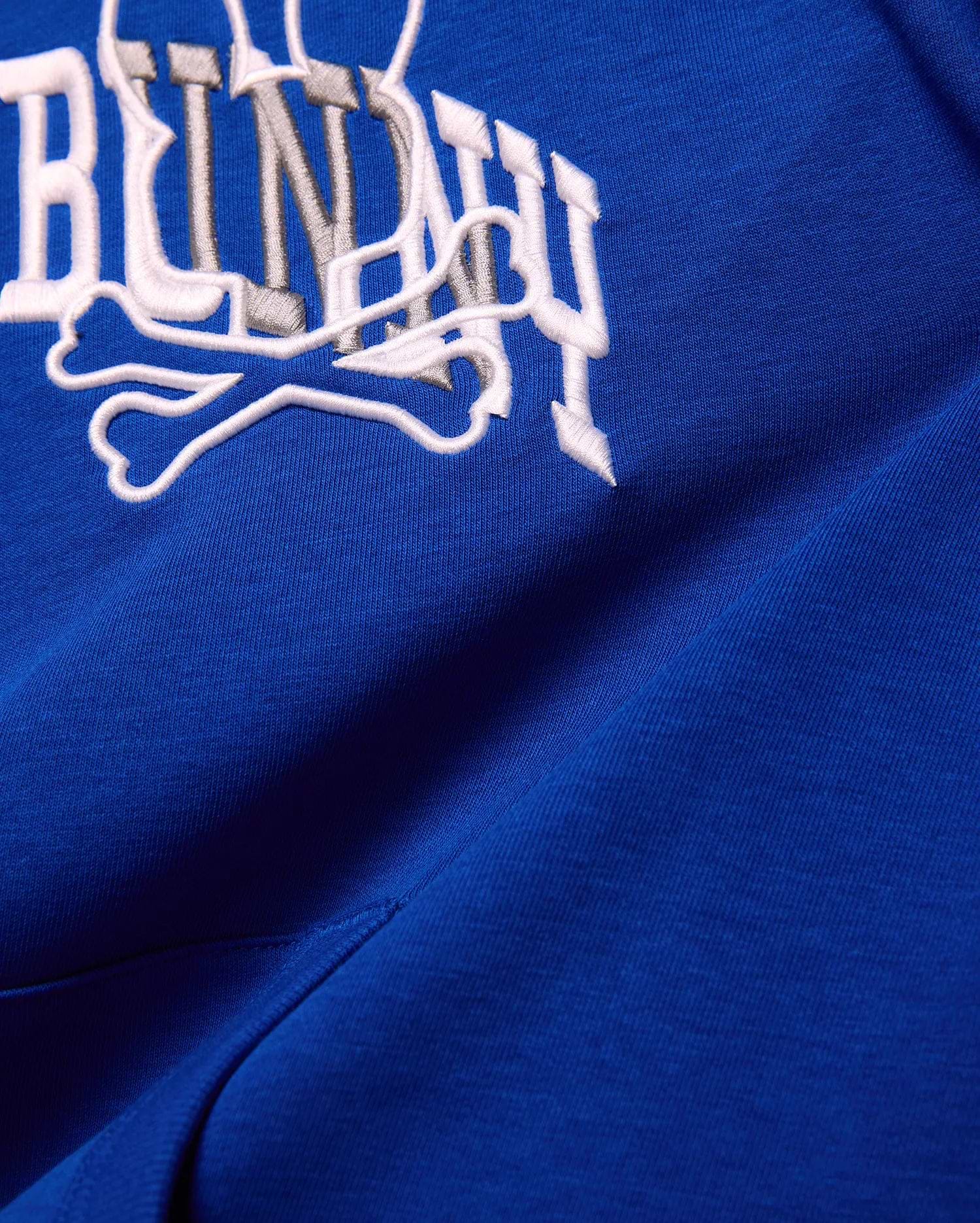 Kids Nathaniel Relaxed Hoodie in royal blue smooth knit, featuring a large embroidered Psycho Bunny wordmark and crossbones logo in white and grey.