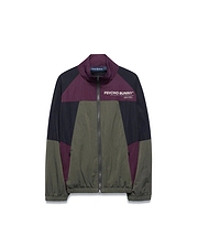 Kids Alder Nylon Colorblock Jacket in olive green, black, and deep purple, featuring a full zip, stand collar, and large white Psycho Bunny chest logo with Designed For Disruption text. Relaxed fit, crinkled nylon.
