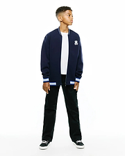 Kids Jaydon Track Jacket in navy, featuring a classic fit, smooth knit fabric, white and blue striped ribbed collar and cuffs, and a small embroidered Psycho Bunny skull logo on the left chest.