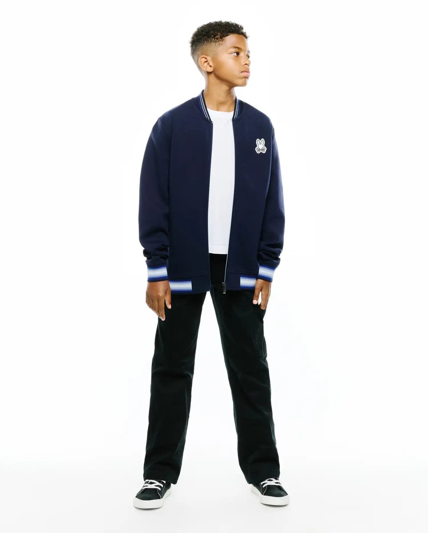 Kids Jaydon Track Jacket in navy, featuring a classic fit, smooth knit fabric, white and blue striped ribbed collar and cuffs, and a small embroidered Psycho Bunny skull logo on the left chest.