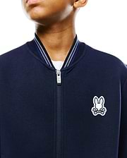 Kids Jaydon Track Jacket, navy smooth jersey, classic fit, full-zip with branded pull, ribbed collar with white and blue stripes, and an embroidered white and light blue Psycho Bunny skull logo on the left chest.