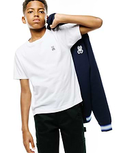 White jersey t-shirt with small embroidered pink and white Psycho Bunny logo, dark green pants, and a navy blue KIDS JAYDON TRACK JACKET with a large white and black Psycho Bunny logo on the sleeve and striped cuffs.