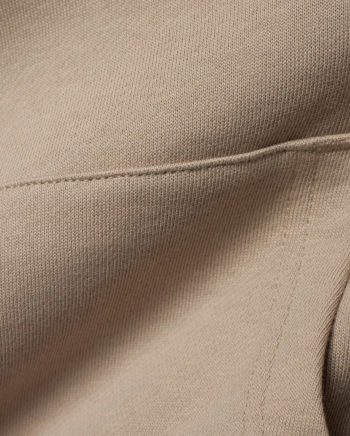 Kids Ty French Terry Hoodie crafted from luxurious, soft beige French terry knit fabric, featuring a meticulously stitched seam detail that highlights the garment's refined construction.