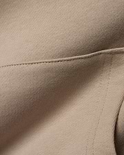 Kids Ty French Terry Hoodie crafted from luxurious, soft beige French terry knit fabric, featuring a meticulously stitched seam detail that highlights the garment's refined construction.