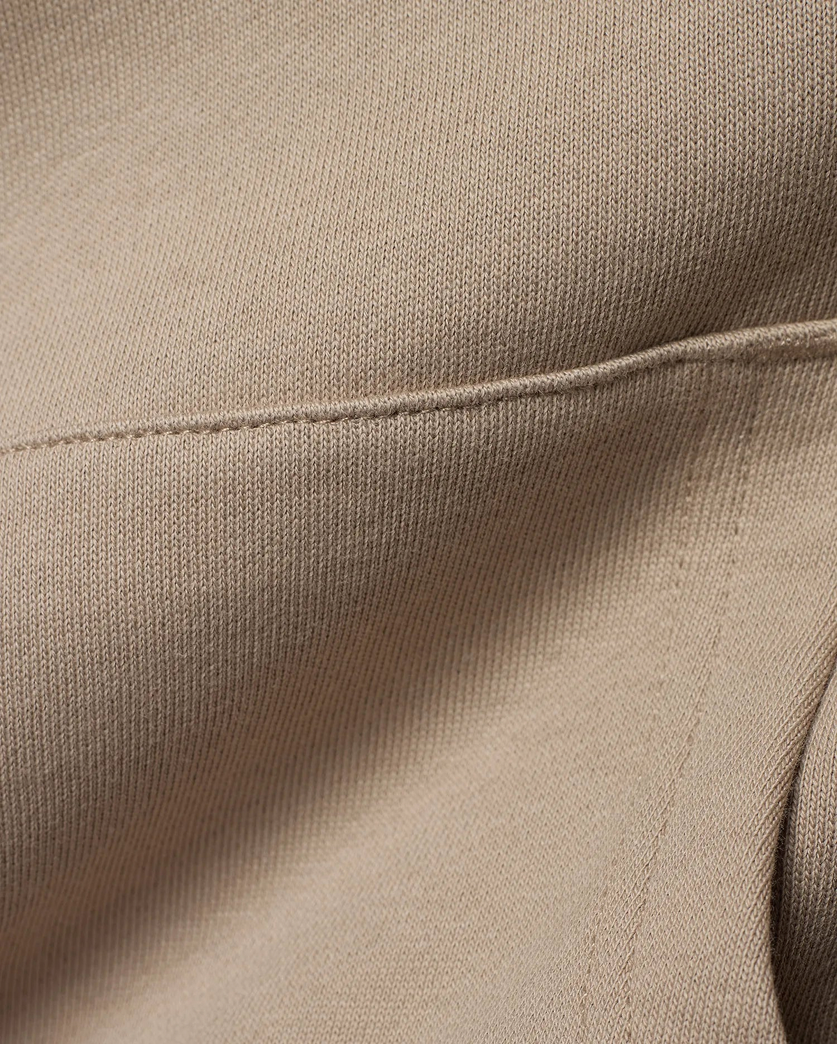 Kids Ty French Terry Hoodie crafted from luxurious, soft beige French terry knit fabric, featuring a meticulously stitched seam detail that highlights the garment's refined construction.