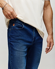 Mens Ace Knit Denim Pant in dark blue with subtle fading, featuring a classic five-pocket design and a small orange Psycho Bunny logo tag on the coin pocket.
