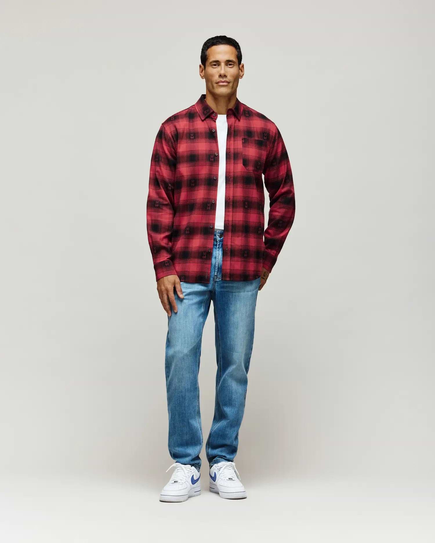 Red and black plaid flannel shirt with subtle all-over Psycho Bunny skull pattern, classic fit, layered over a white jersey t-shirt, paired with light wash Mens Emerson Denim Pant.