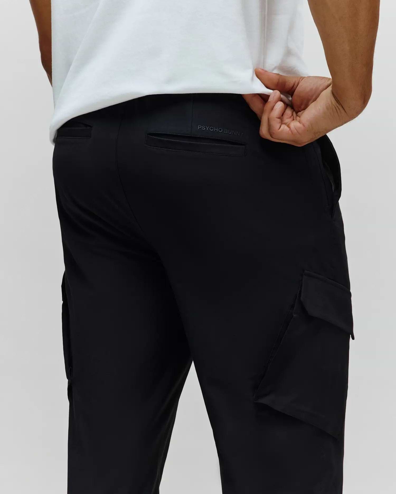 Black Mens Luka Cargo Pant in a relaxed fit, featuring a smooth, durable fabric, practical side cargo pockets, and subtle embossed PSYCHO BUNNY branding on the back waistband.