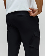 Black Mens Luka Cargo Pant in a relaxed fit, featuring a smooth, durable fabric, practical side cargo pockets, and subtle embossed PSYCHO BUNNY branding on the back waistband.
