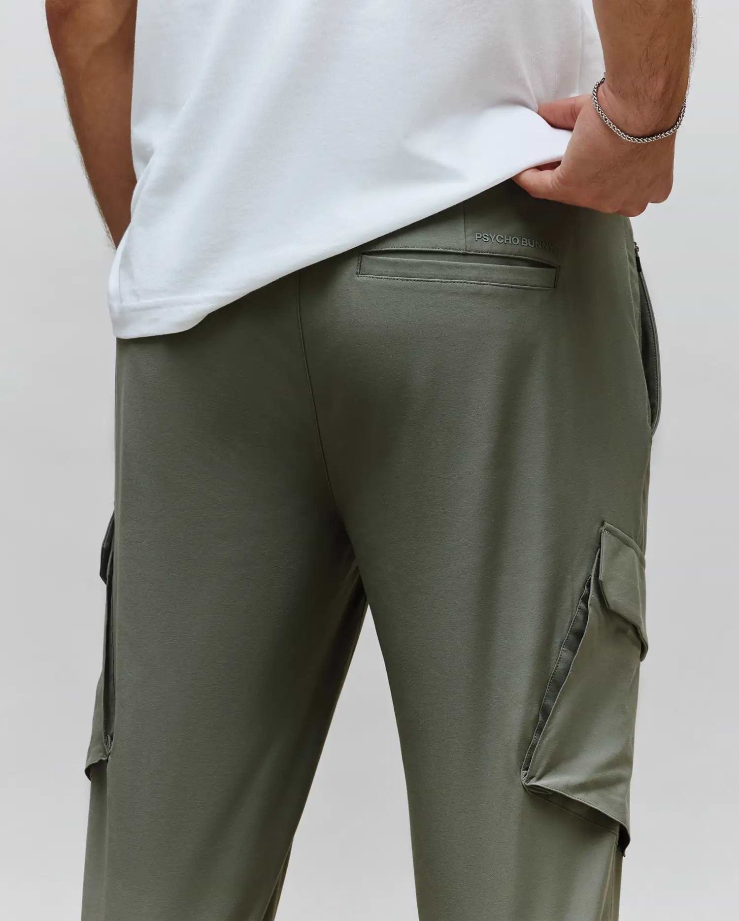 Mens Luka Cargo Pant in olive green, a relaxed fit style crafted from smooth jersey fabric, featuring prominent side cargo pockets and a debossed Psycho Bunny text logo above the back pocket.
