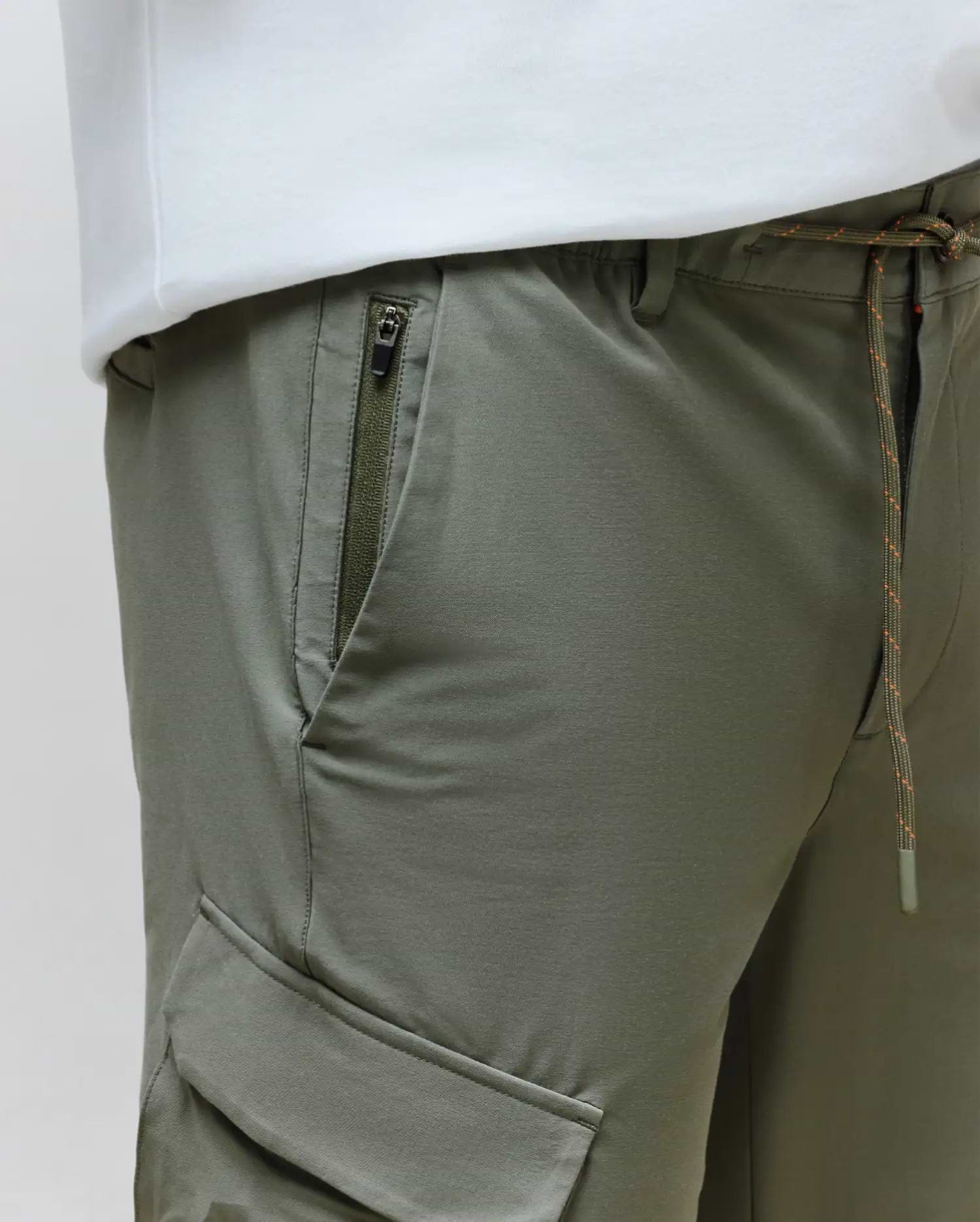 Mens Luka Cargo Pant in olive green, crafted from smooth technical fabric, featuring a drawstring waist with orange flecks, a zippered hip pocket, and a side cargo pocket for a relaxed fit.