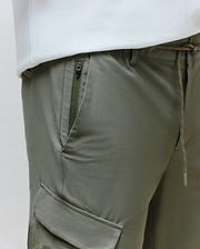 Mens Luka Cargo Pant in olive green, crafted from smooth technical fabric, featuring a drawstring waist with orange flecks, a zippered hip pocket, and a side cargo pocket for a relaxed fit.