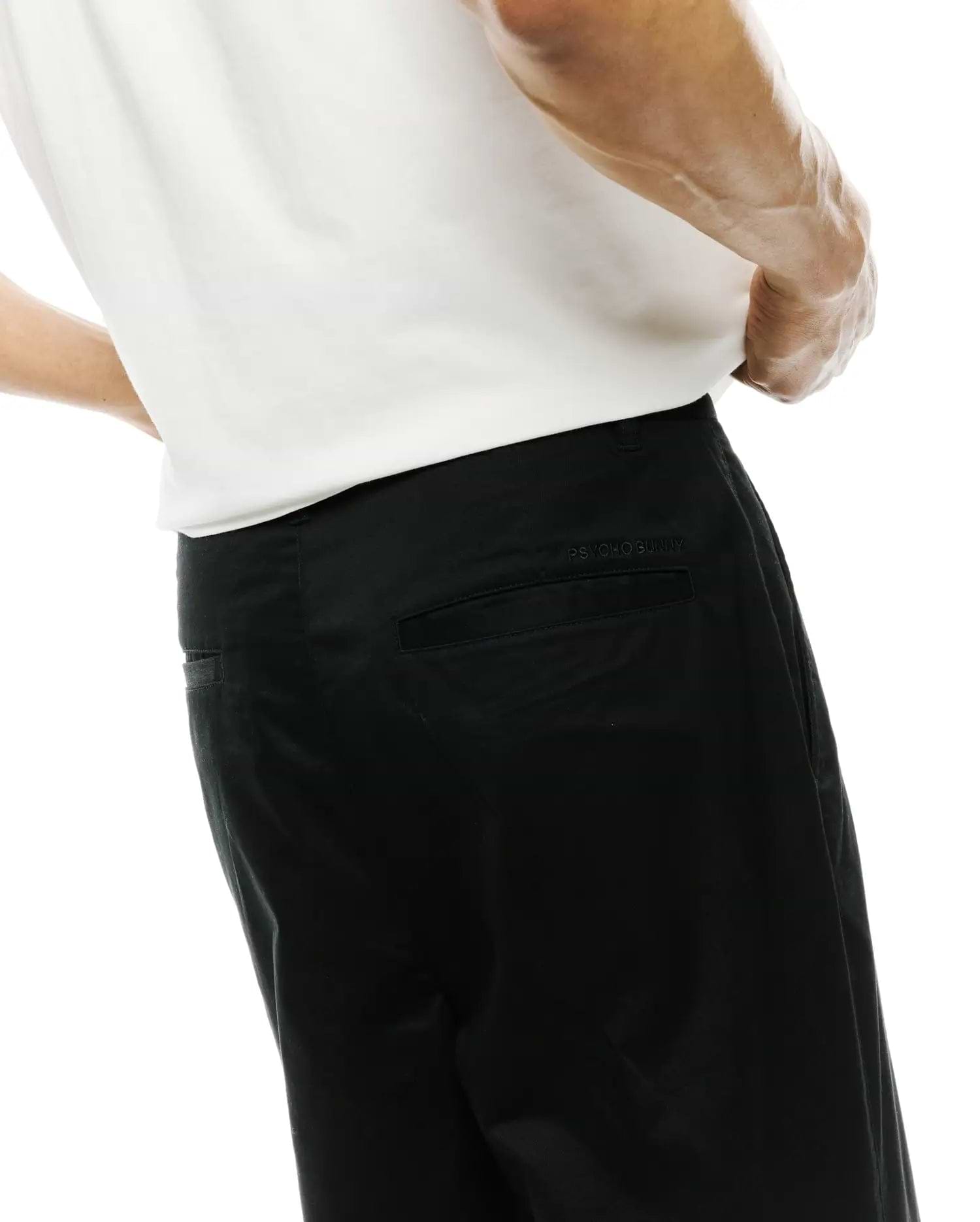 Mens Aidan Chino Pant, a premium black cotton twill with a classic fit and subtle tonal embroidered Psycho Bunny text above the back right pocket. (2)