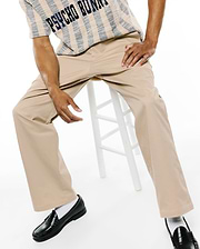 MENS AIDAN CHINO PANT in relaxed fit khaki twill, paired with a cream and navy striped textured knit short-sleeve shirt featuring large PSYCHO BUNNY text across the chest.