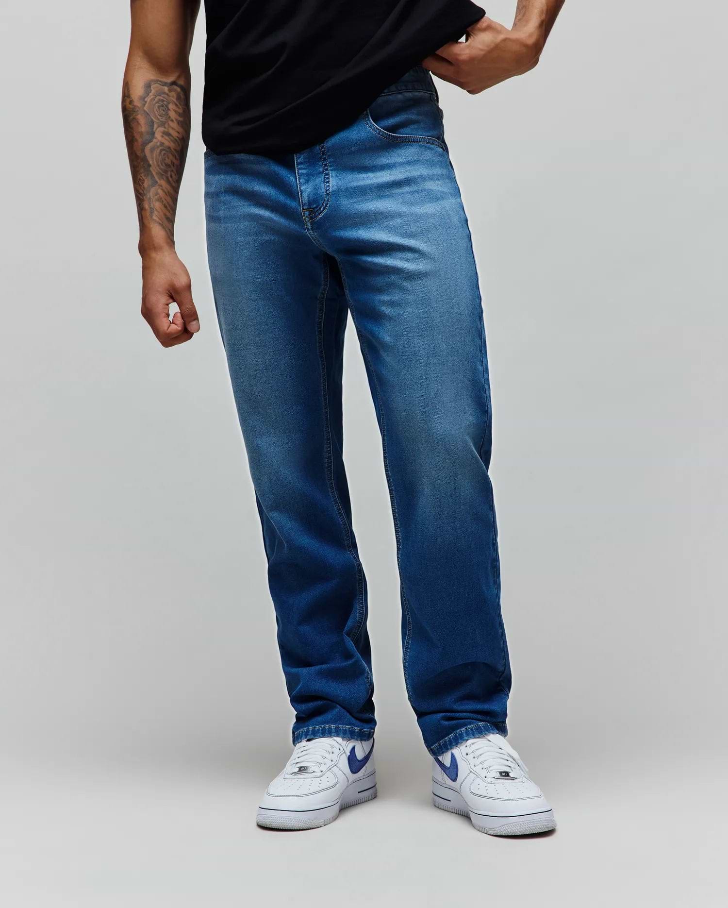 Mens Ace Knit Denim Pant, a classic straight fit jean in a versatile medium wash blue knit denim fabric, featuring subtle whiskering and fading for a refined streetwear look.