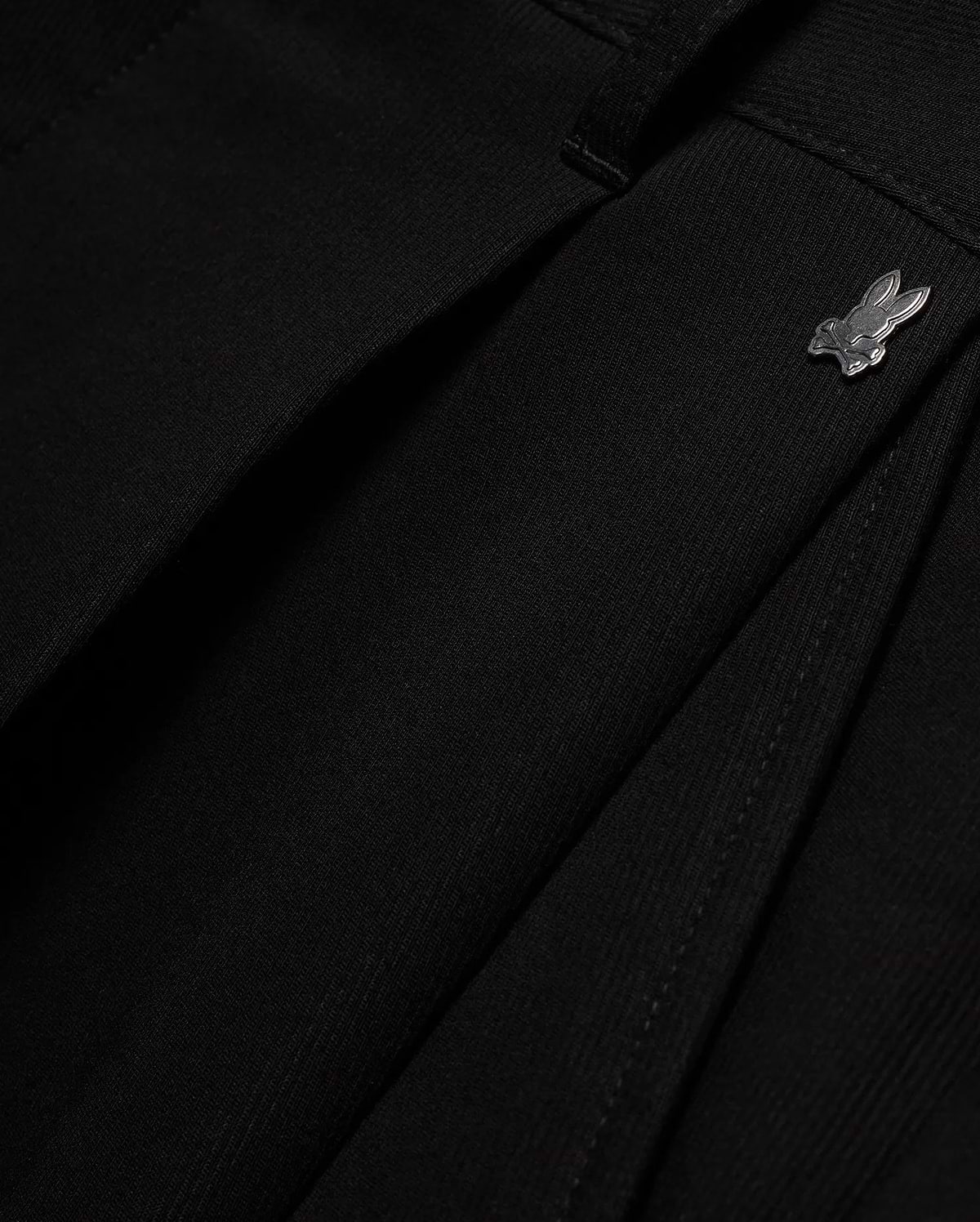 Men's Wayde Wide-Leg Pleated Pants in black, featuring a subtle fabric texture, wide-leg fit, and a small metallic silver Psycho Bunny skull logo near the waistband. (6)